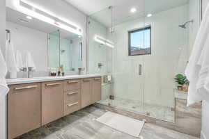 Bathroom featuring vanity and a shower with shower door