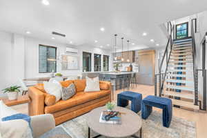 Living room with a wall mounted air conditioner and light wood-type flooring