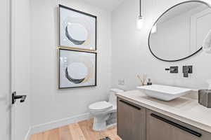 Bathroom with vanity, hardwood / wood-style flooring, and toilet