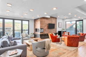 Living room featuring plenty of natural light, light hardwood / wood-style floors, and a textured ceiling