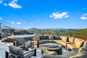 View of patio / terrace with a mountain view, outdoor lounge area, and a hot tub