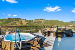 Wooden deck featuring outdoor lounge area, a mountain view, and a hot tub