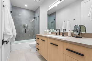 Full bathroom featuring tile patterned flooring, vanity, toilet, and shower / bath combination with glass door