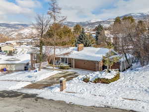 View of front of house with a mountain view and a garage