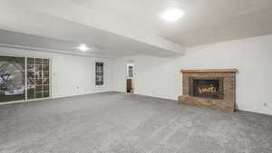 Unfurnished living room featuring carpet, a textured ceiling, and a fireplace