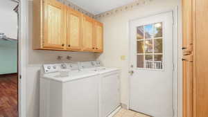 Laundry area featuring cabinets, independent washer and dryer, and light wood-type flooring