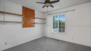 Carpeted spare room featuring ceiling fan