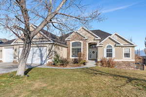 View of front of house featuring a garage and a front yard