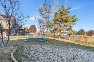 View of yard with in-ground trampoline included.