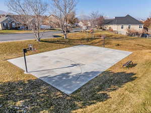 View of sport court with a lawn