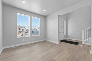 Foyer entrance with light hardwood / wood-style floors and a textured ceiling