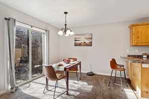 Dining room featuring carpet and an inviting chandelier