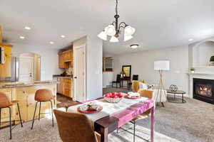 Carpeted dining space with an inviting chandelier and sink