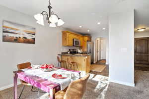 Carpeted dining space with a chandelier