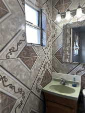 Bathroom with vanity and tile walls