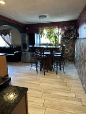 Dining area featuring a textured ceiling and light hardwood / wood-style flooring