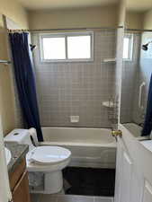 Full bathroom with tile patterned flooring, plenty of natural light, toilet, and vanity