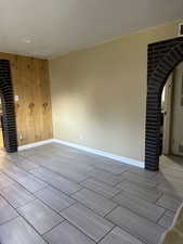 Empty room with wood walls and light wood-type flooring