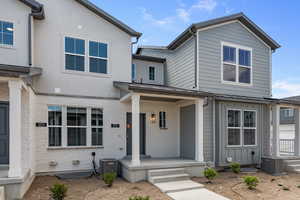 View of front facade featuring a porch and cooling unit