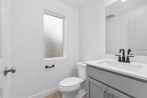 Bathroom with plenty of natural light, vanity, wood-type flooring, and toilet