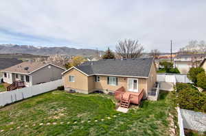 Rear view of house featuring a yard and a deck with mountain view