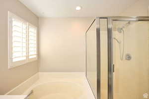 Bathroom featuring plus walk in shower and a textured ceiling