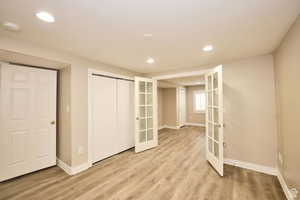 Interior space with french doors, light hardwood / wood-style floors, and a closet