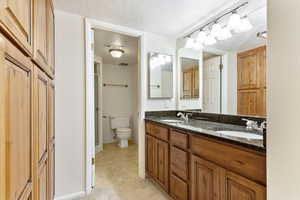 Bathroom with vanity, a textured ceiling, and toilet