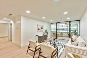 Living room featuring floor to ceiling windows and light hardwood / wood-style floors