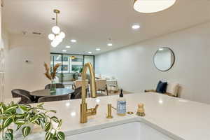 Kitchen featuring floor to ceiling windows and decorative light fixtures