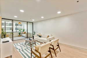 Living room featuring floor to ceiling windows and light wood-type flooring