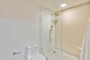 Bathroom with toilet and curtained shower