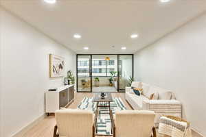 Living room featuring light hardwood / wood-style floors and a wall of windows