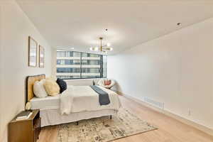 Bedroom with light wood-type flooring and a chandelier