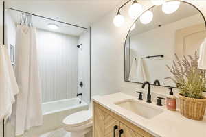 Full bathroom featuring shower / bath combo, vanity, and toilet