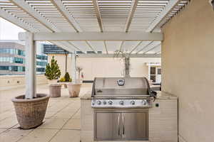 View of patio with an outdoor kitchen, area for grilling, and a pergola