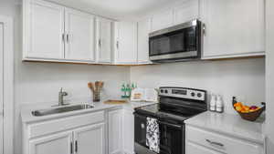 Kitchen featuring white cabinets, sink, and stainless steel appliances