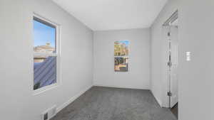 Unfurnished room with dark colored carpet