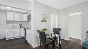 Dining space with dark wood-type flooring and sink