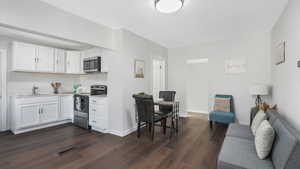 Kitchen featuring white cabinetry, sink, dark hardwood / wood-style floors, and appliances with stainless steel finishes