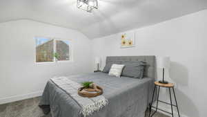 Bedroom with carpet, a textured ceiling, and lofted ceiling