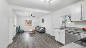 Kitchen with a wealth of natural light, white cabinetry, dishwasher, and sink