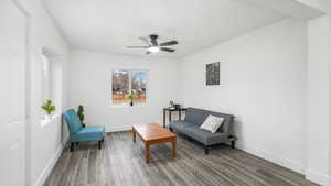 Living area with hardwood / wood-style flooring and ceiling fan