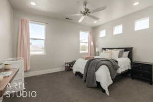 Bedroom featuring dark colored carpet, multiple windows, and ceiling fan