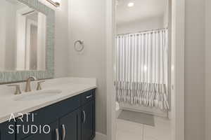 Full bathroom with tile patterned flooring, vanity, shower / bath combination with curtain, and toilet