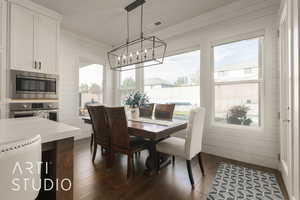 Dining space with wood walls and dark hardwood / wood-style flooring