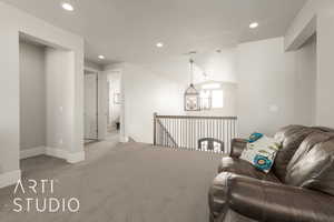 Living room featuring light colored carpet, lofted ceiling, and a notable chandelier