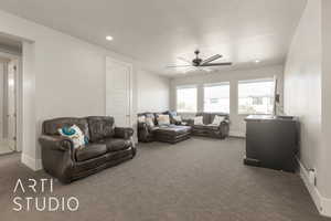 Carpeted living room featuring ceiling fan