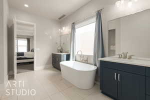 Bathroom with tile patterned floors, vanity, and a tub