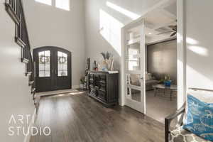 Entryway featuring french doors, a towering ceiling, and dark hardwood / wood-style floors